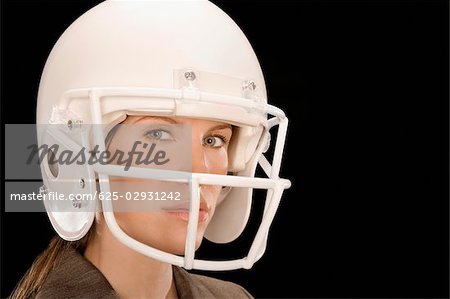 Portrait of smiling woman in American football uniform and helmet. Stock  Photo