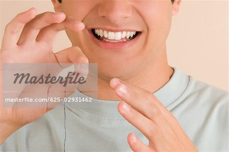 Close-up of a young man pinching a needle in his finger