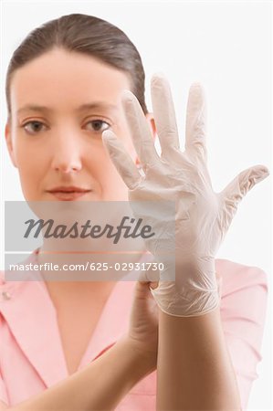 Female nurse putting on a surgical glove