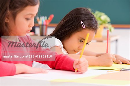 Two girls drawing in a classroom