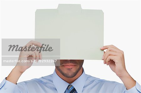 Close-up of a businessman holding a placard in front of his face