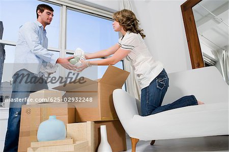 Young couple unpacking cardboard boxes