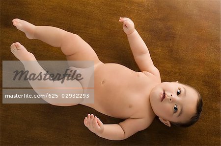 Close-up of a baby boy lying on the floor