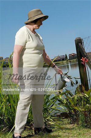 Senior woman watering plants in a garden