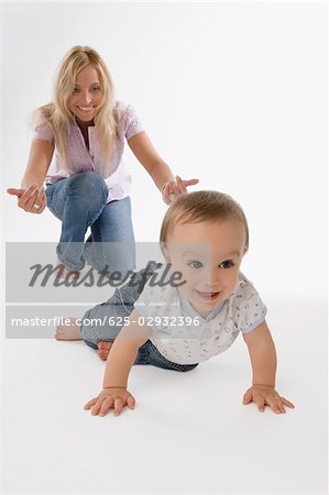 Mid adult woman playing with her baby boy and smiling