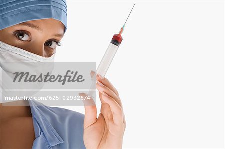 Portrait of a female surgeon holding a syringe