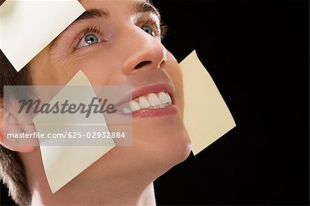 Close-up of a businessman covered with adhesive notes and day dreaming
