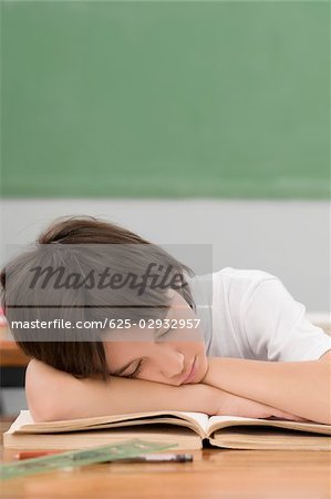 Schoolboy napping on a desk in a classroom