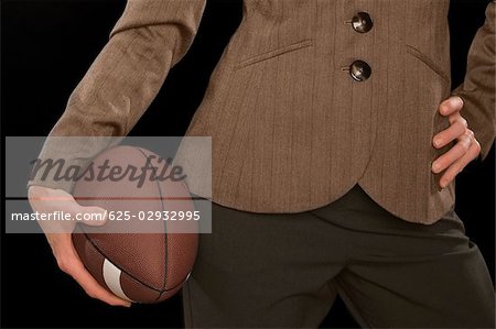 Close-up of a businesswoman holding an American football