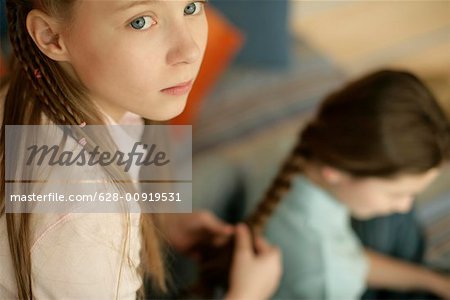 Girl plaiting friend's hair