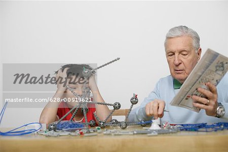 Grandfather and boy playing with a construction kit, fully_released