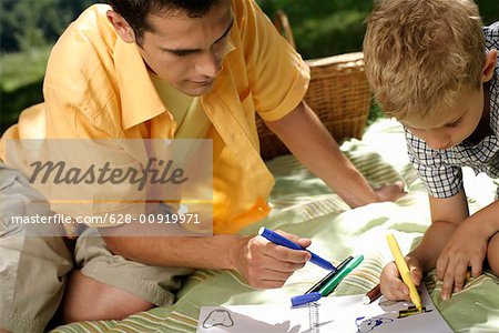 Father and son drawing into booklet