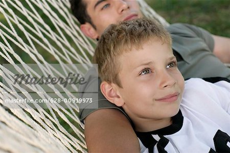 Father and son lying together in a hammock