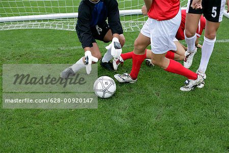 Soccer players in action in the goal area