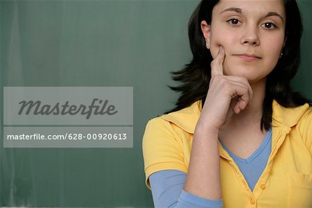 Portrait of a teenage girl in front of a blackboard