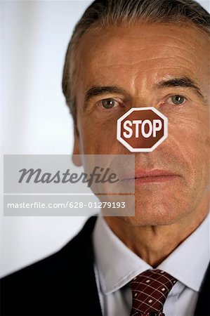 Senior businessman with a STOP label on his nose