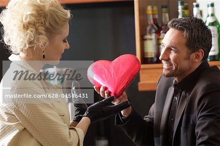 Man giving young woman a chocolate heart