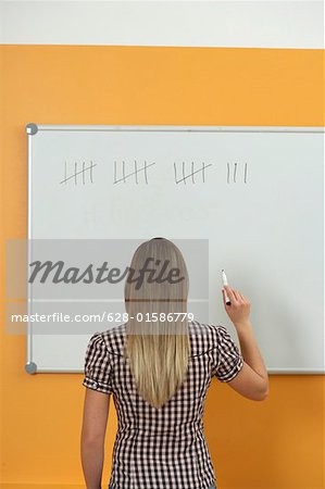 A woman writing on a white board