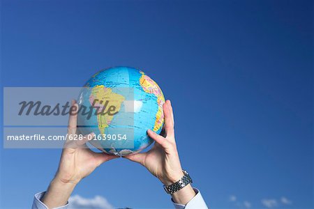 Businessman holding globe up