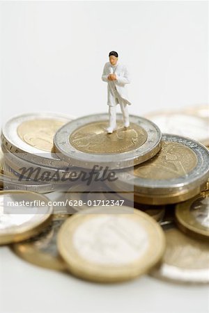 Figurine of a doctor on a heap of coins