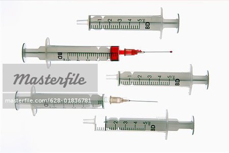 Five syringes, one filled with red liquid