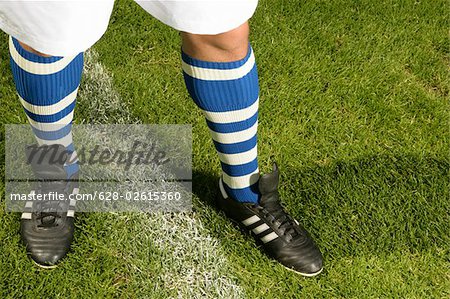 Legs of a footballer with blue and white striped stockings (part of), close-up