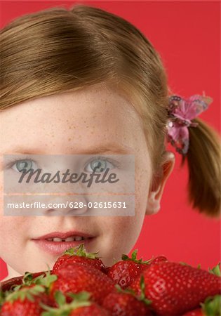 Girl (4-5 years) with a bowl of strawberries