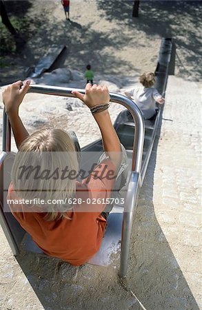 Blonde Boy at the upper End of a Slide - Playground - Summer