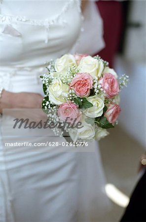 Woman in a Wedding Dress holding a Bunch of Flowers in her Hand - Symbolism - Wedding