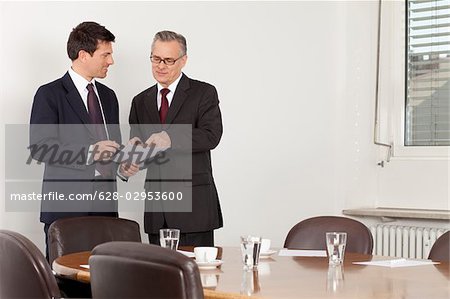 Two businessmen talking in conference room, Munich, Bavaria, Germany