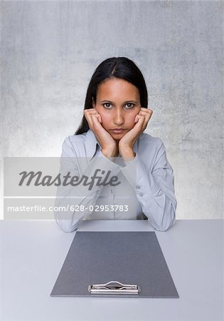 Woman sitting with empty clipboard at table