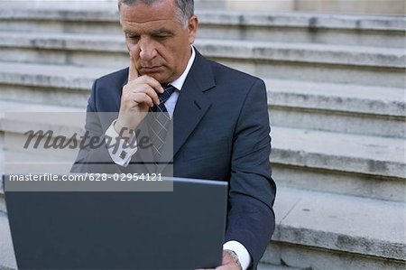 Man with laptop sitting on a stairway