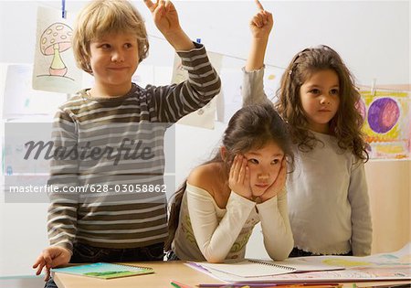 Three schoolchildren in classroom