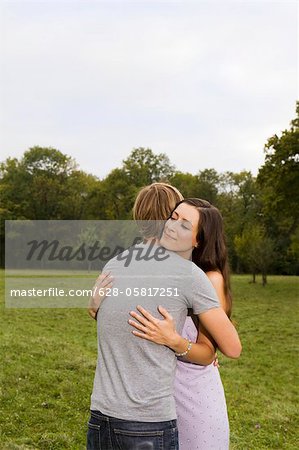 Happy couple embracing in meadow, Munich, Bavaria, Germany