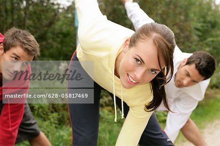 Two men and a woman bending over