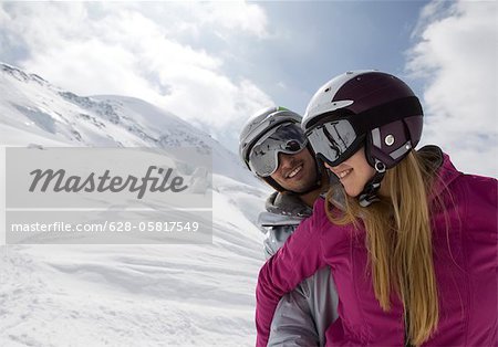 Couple wearing ski suits in alpine winter landscape