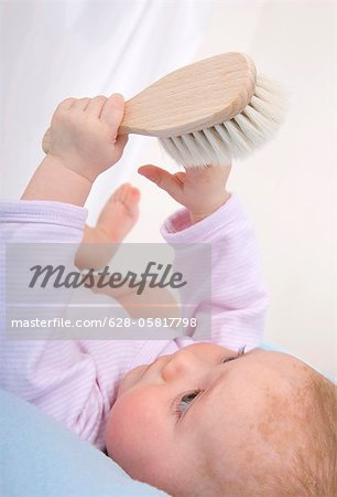 Baby holding hair brush