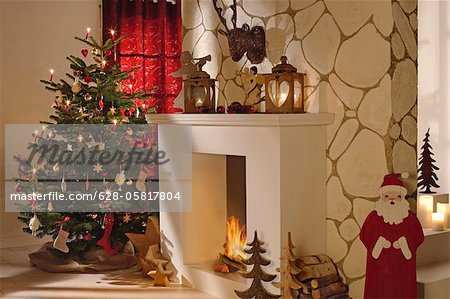 Christmas tree next to fireplace with Christmas decoration