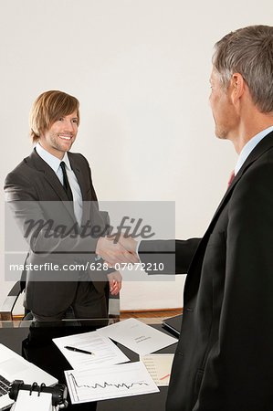 Two businessmen shaking hands in office