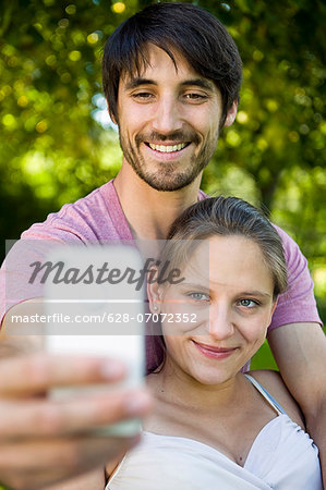 Happy couple taking self portrait outdoors