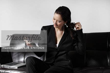 Businesswoman using smartphone on couch