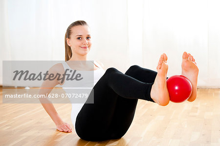 Teenage girl exercising with gymnastics ball - Stock Photo - Masterfile -  Premium Royalty-Free, Code: 628-07072479