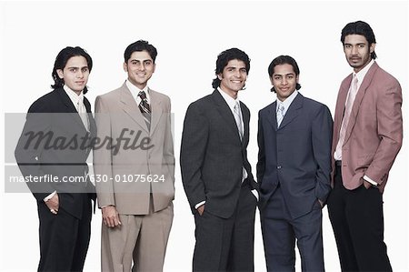 Portrait of five businessmen standing with their hands in their pockets