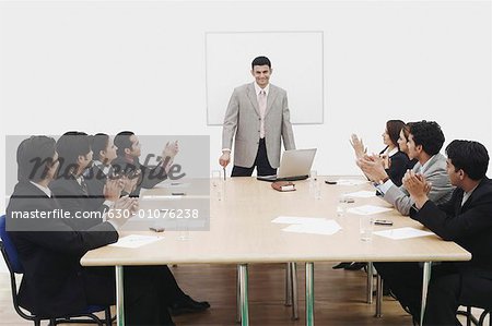 Group of business executives applauding at a presentation