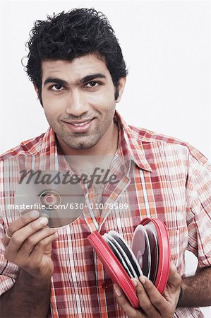 Portrait of a young man holding CDs and smiling