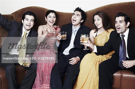 Three young men and two young women holding glasses