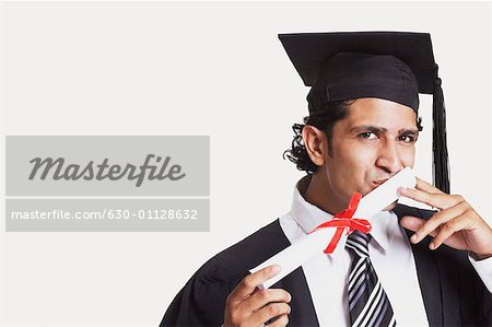 Portrait of a male graduate kissing his diploma