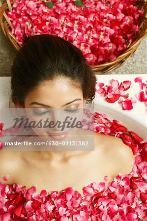 High angle view of a young woman in a bathtub full of rose petals