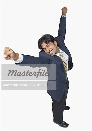 High angle view of a businessman standing with his arms raised and smiling