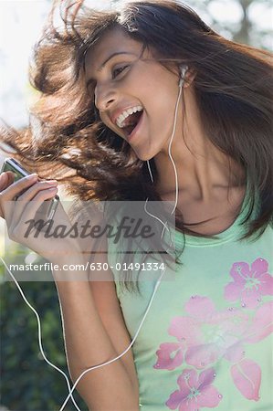 Close-up of a young woman listening to an MP3 player